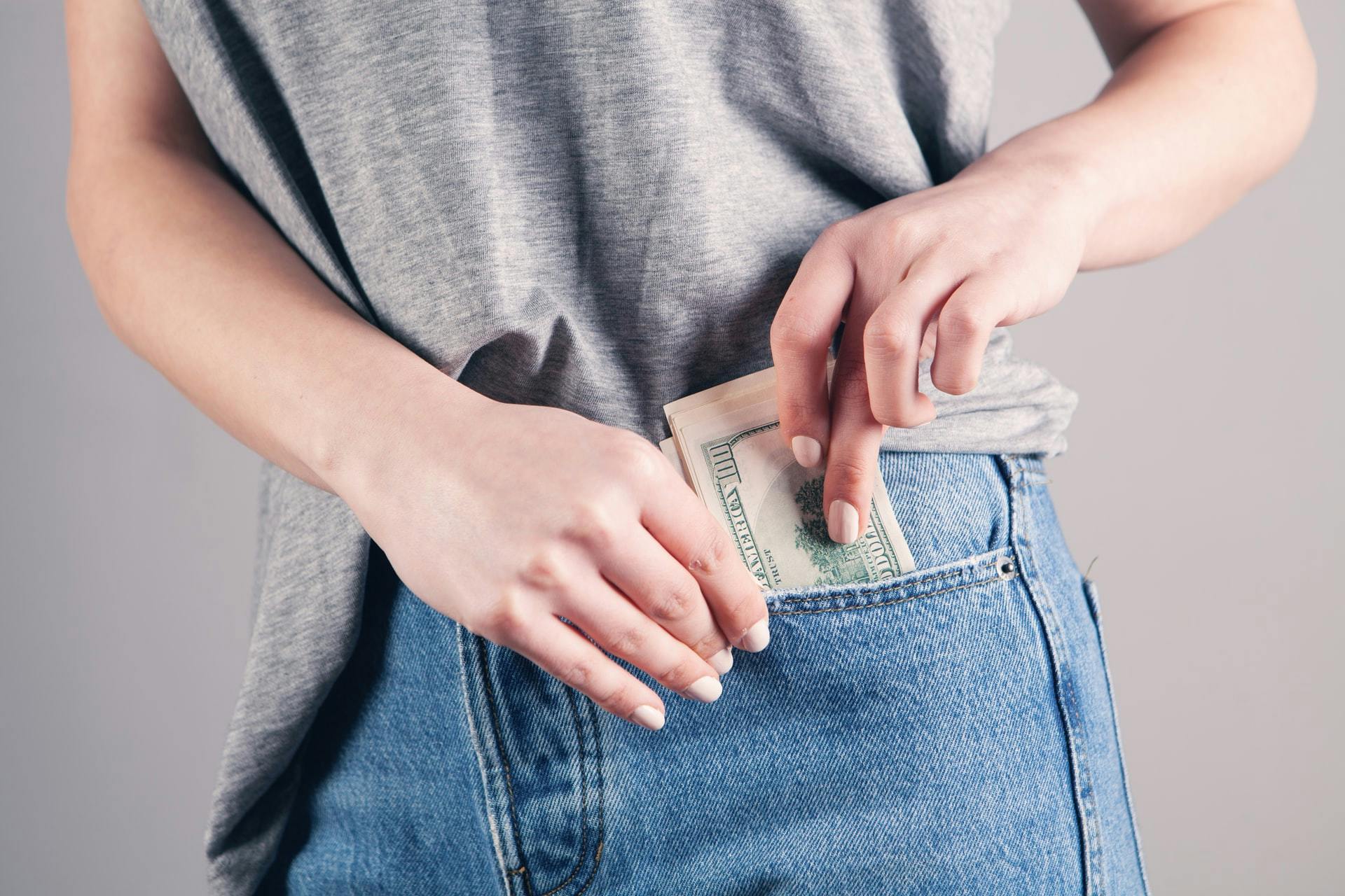 mujer guardando dolares en bolsillo