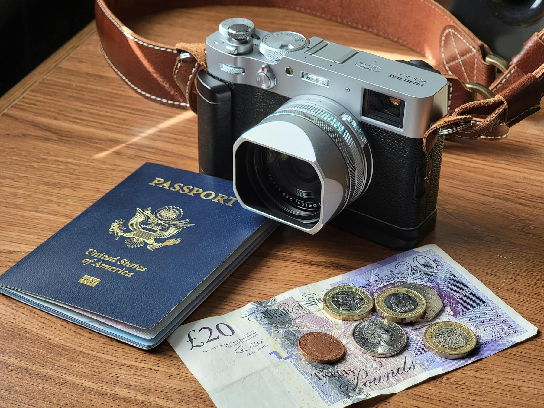 A DSLR camera next to a passport and foreign currency