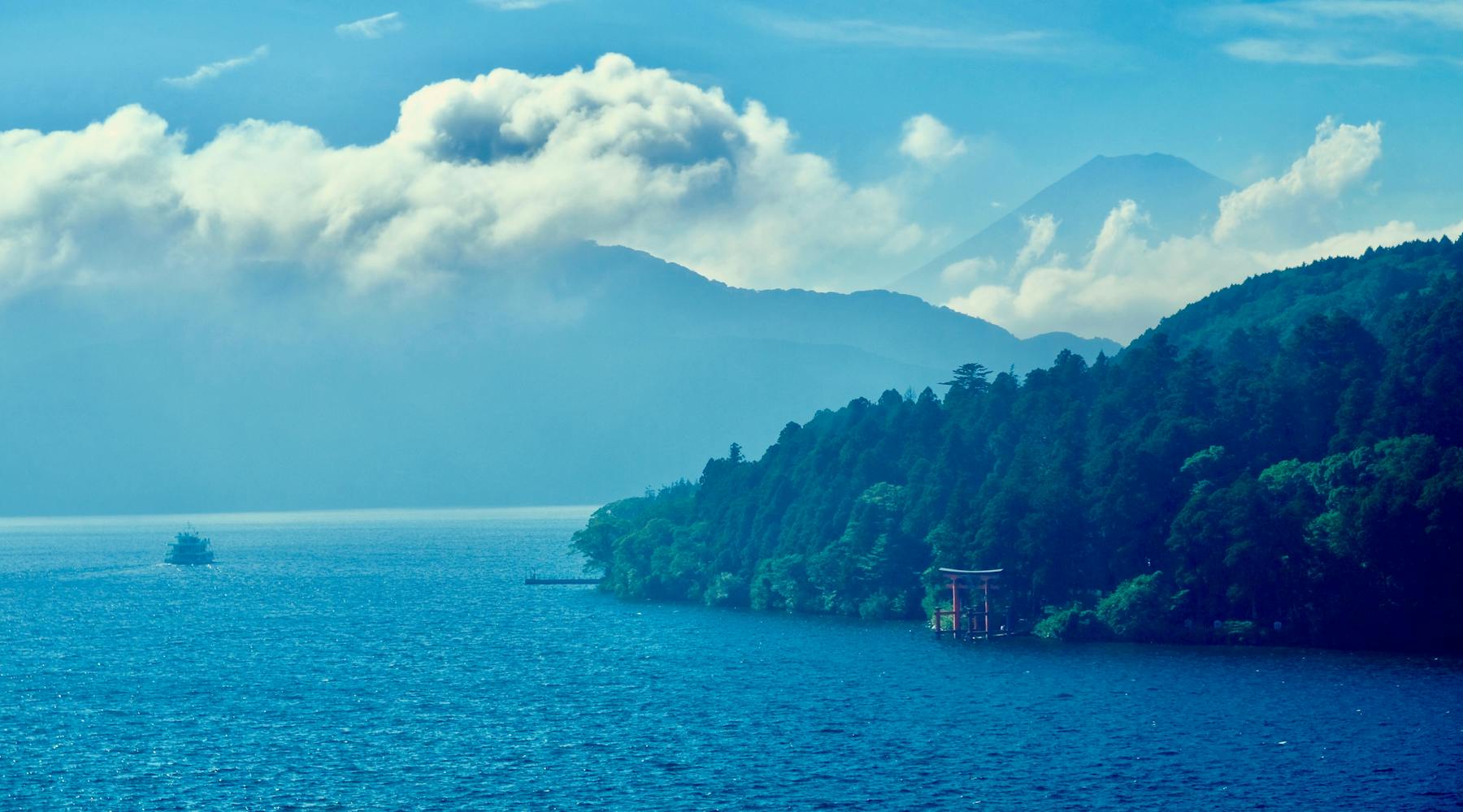 Torii gate and sailboat in Lake Hakone with Mount Fuji, Japan
