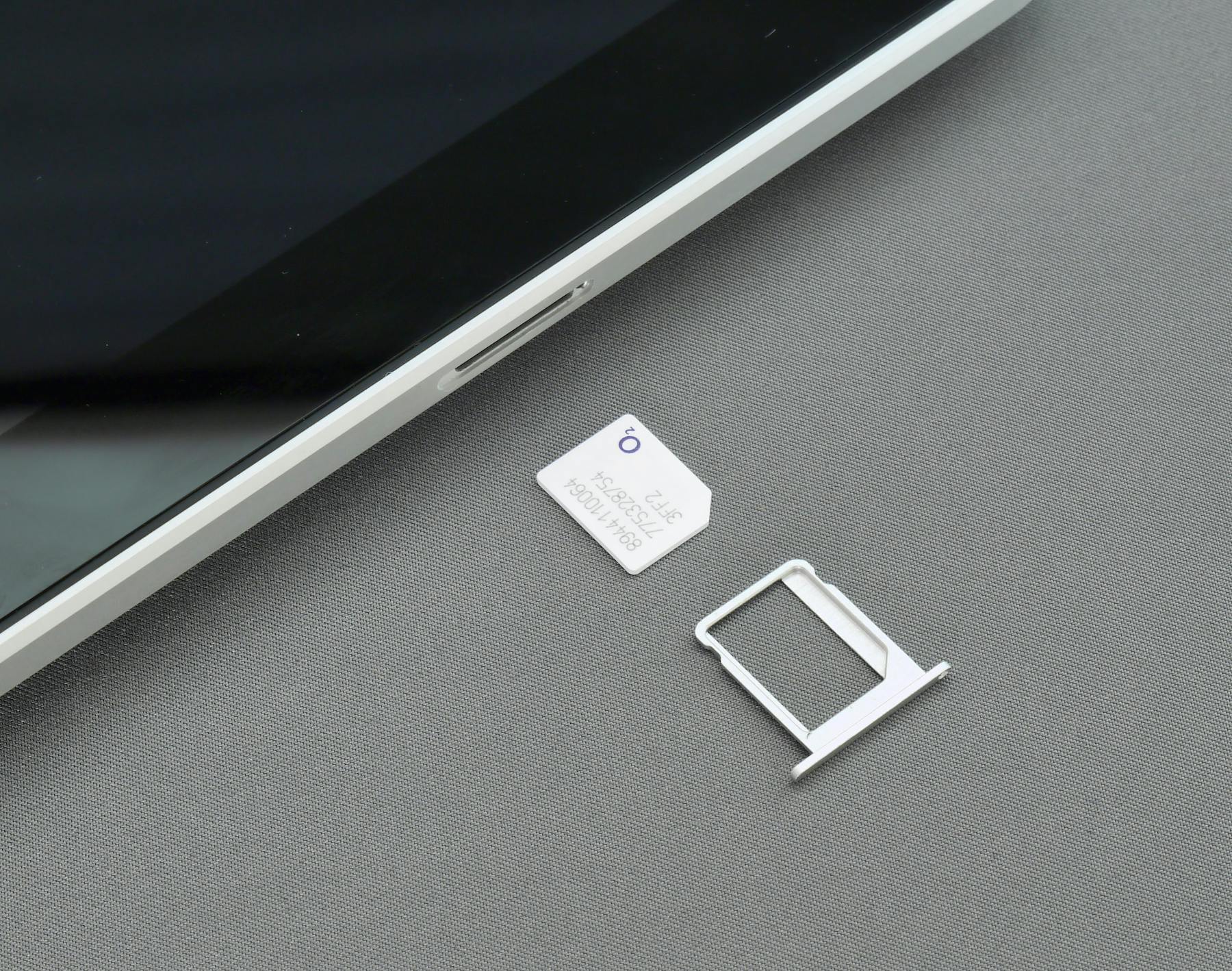 SIM card and adapter next to an iPad.