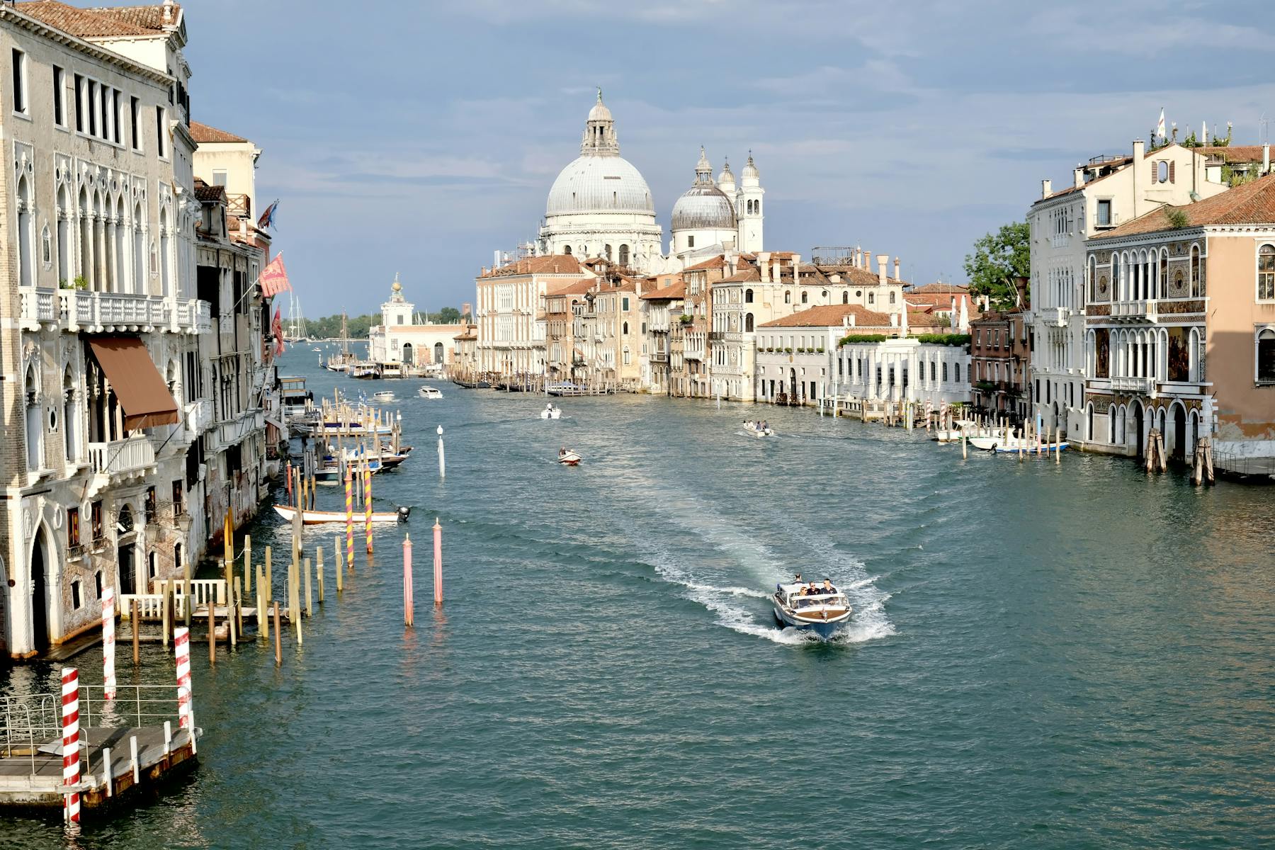 Boats passing below Ponte dell'Accademia overlooking the Basilica di Santa Maria della Salute in Venice, Italy