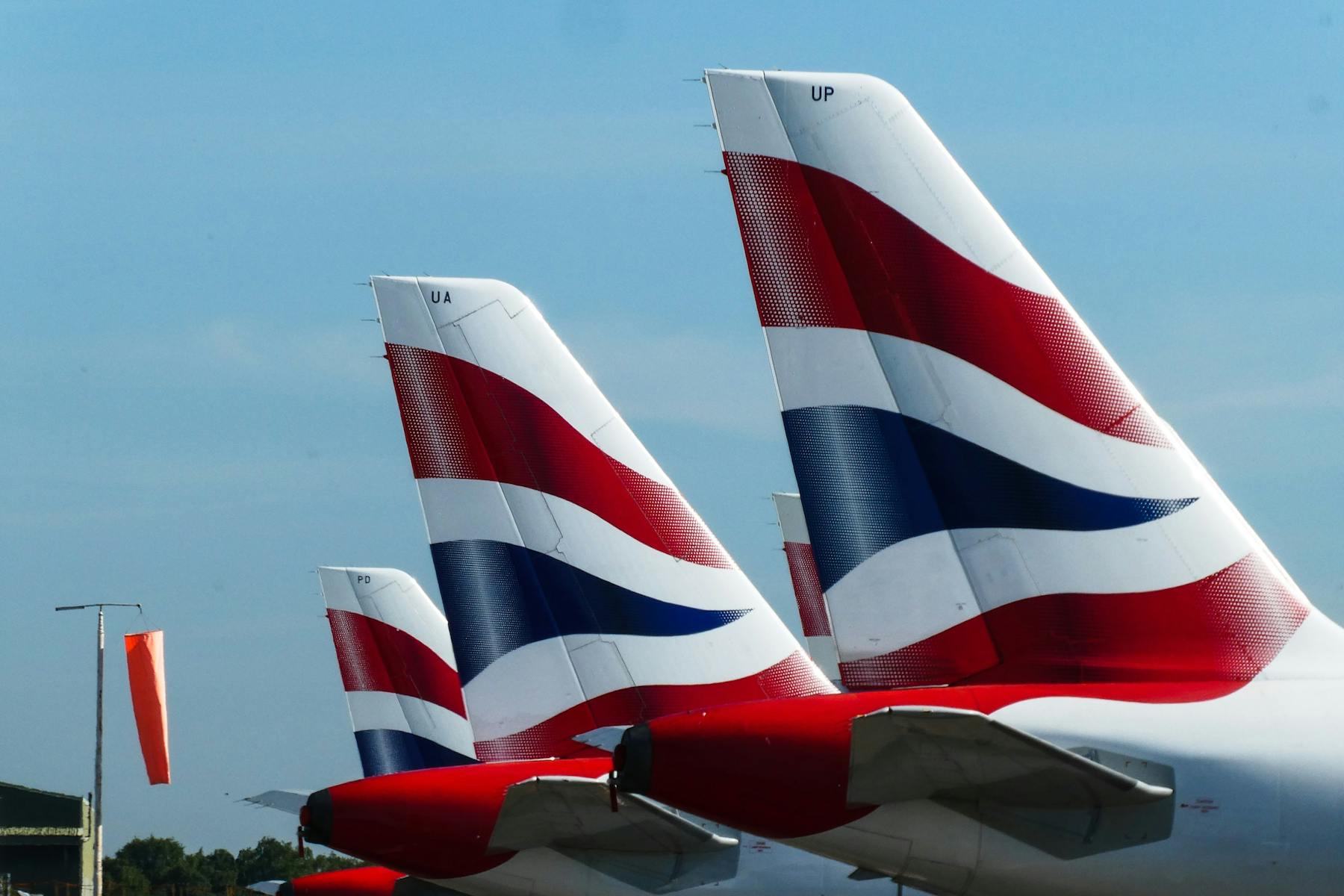 Tails of three British Airways aircraft parked at Bournemouth Airport.