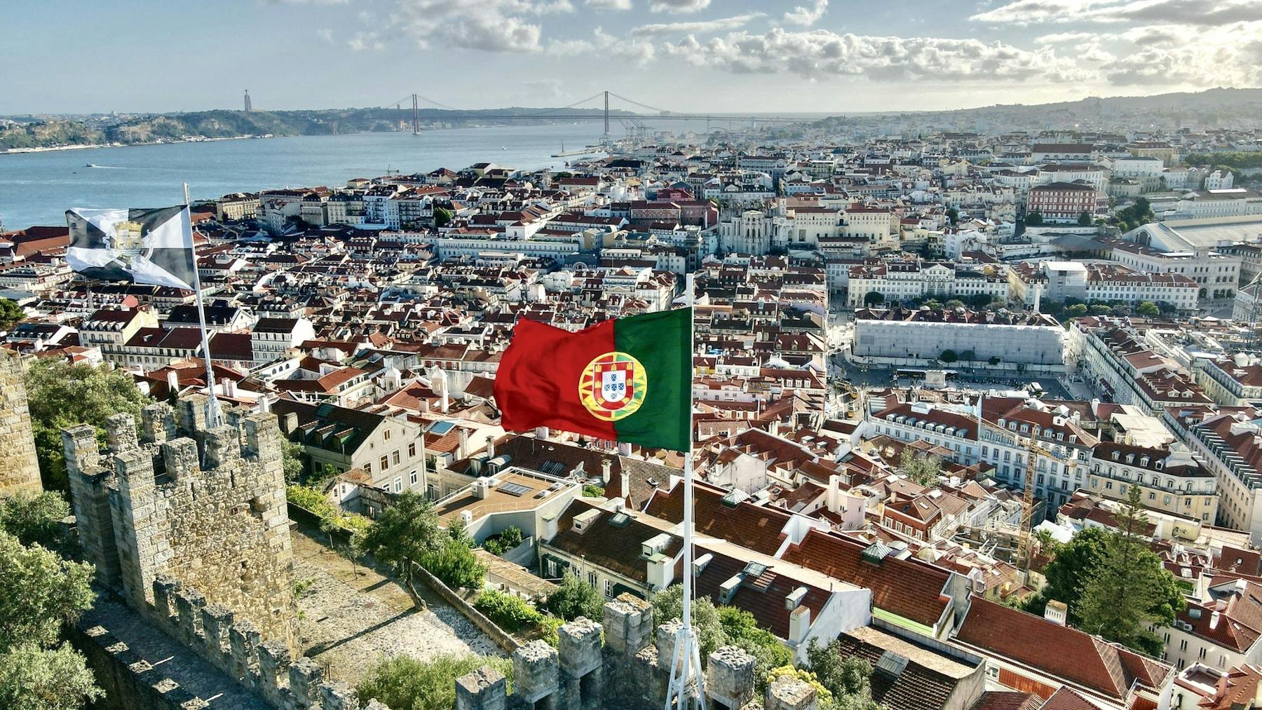 Bandeira de Portugal hasteada com a cidade de Lisboa ao fundo
